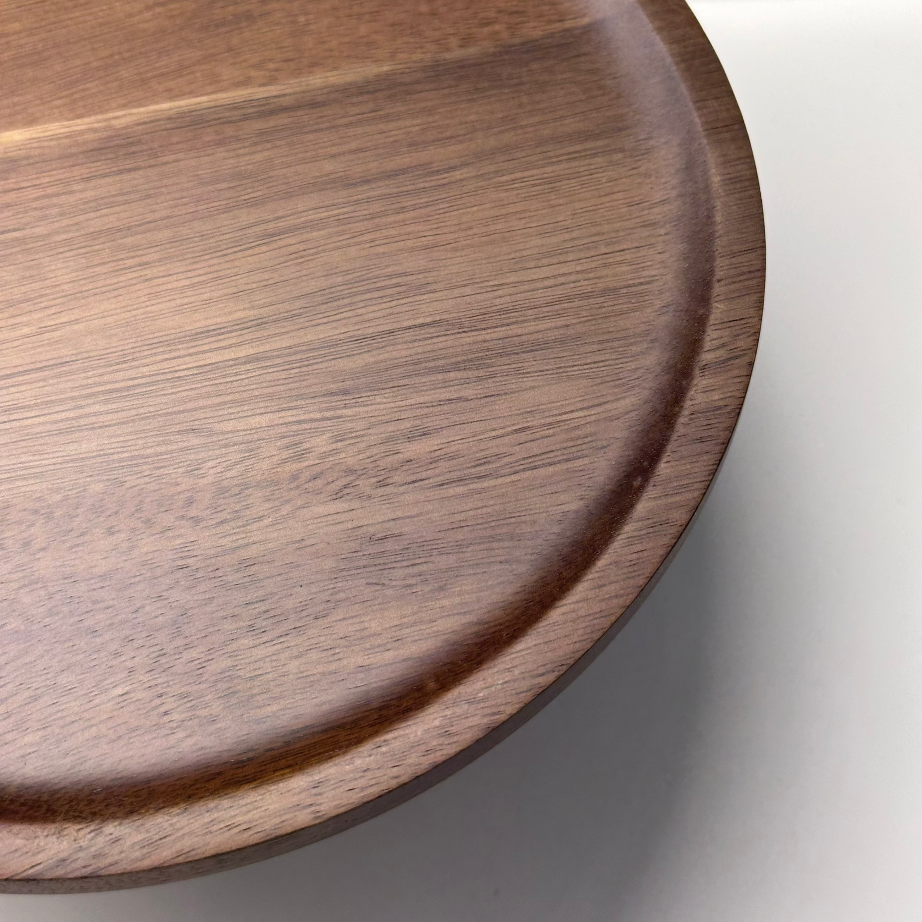 Wooden cake stand tray on a light gray background close up