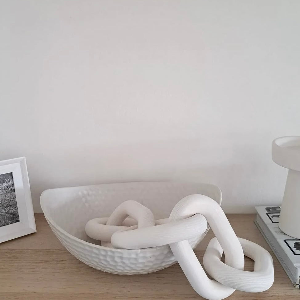 White ceramic bowl showcasing a white decorative wooden boho chain link